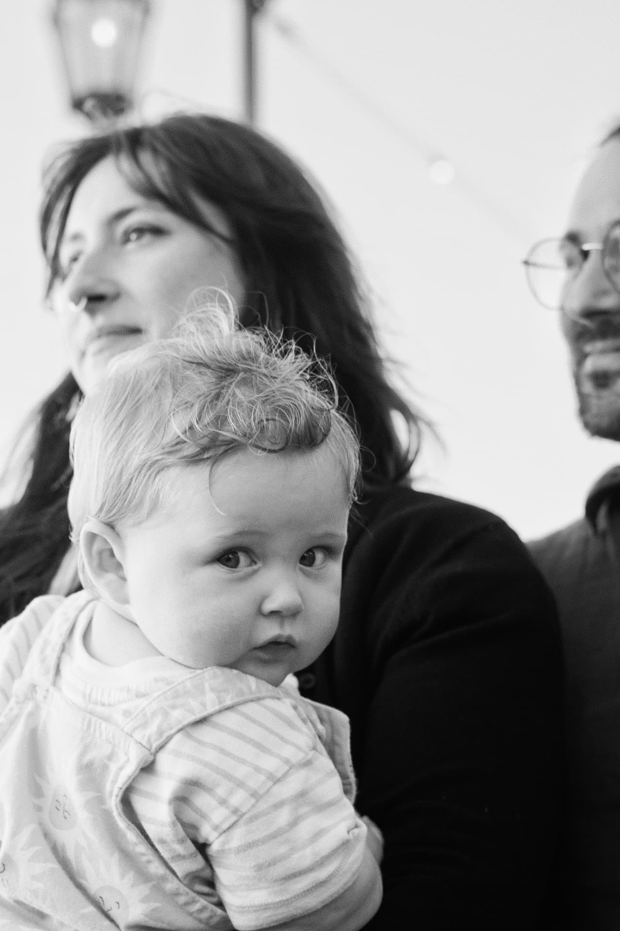 Black and white portrait of the Espicha-Blumenstein baby resting in her parents' arms