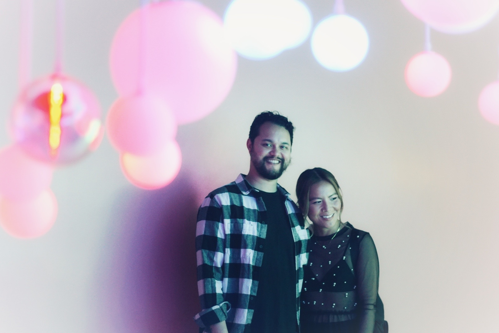 Kim and Nick photographed through soft colorful lights during their engagement photoshoot