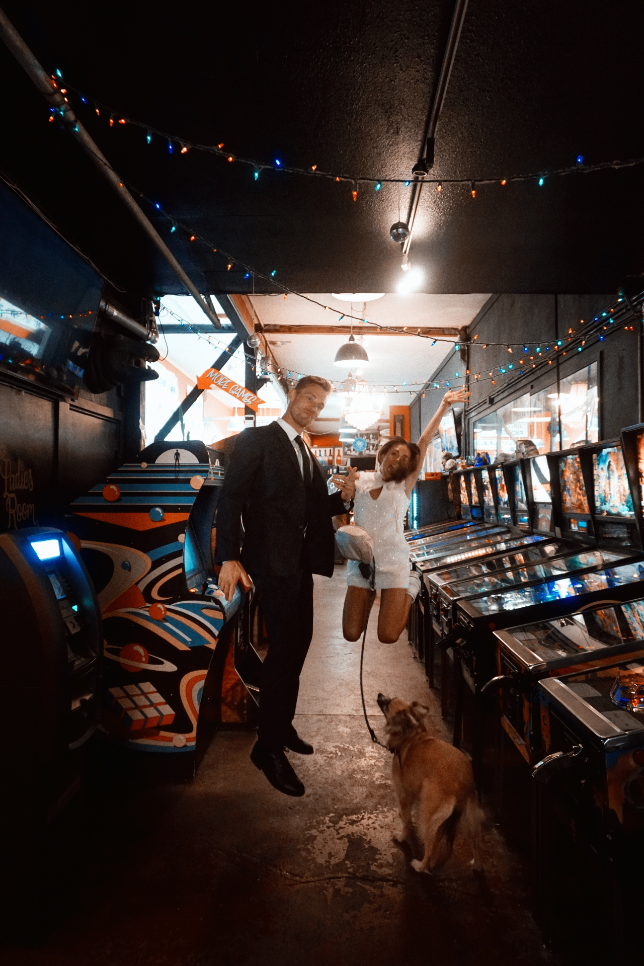Maggie and Jono celebrating in an arcade after their City Hall photoshoot