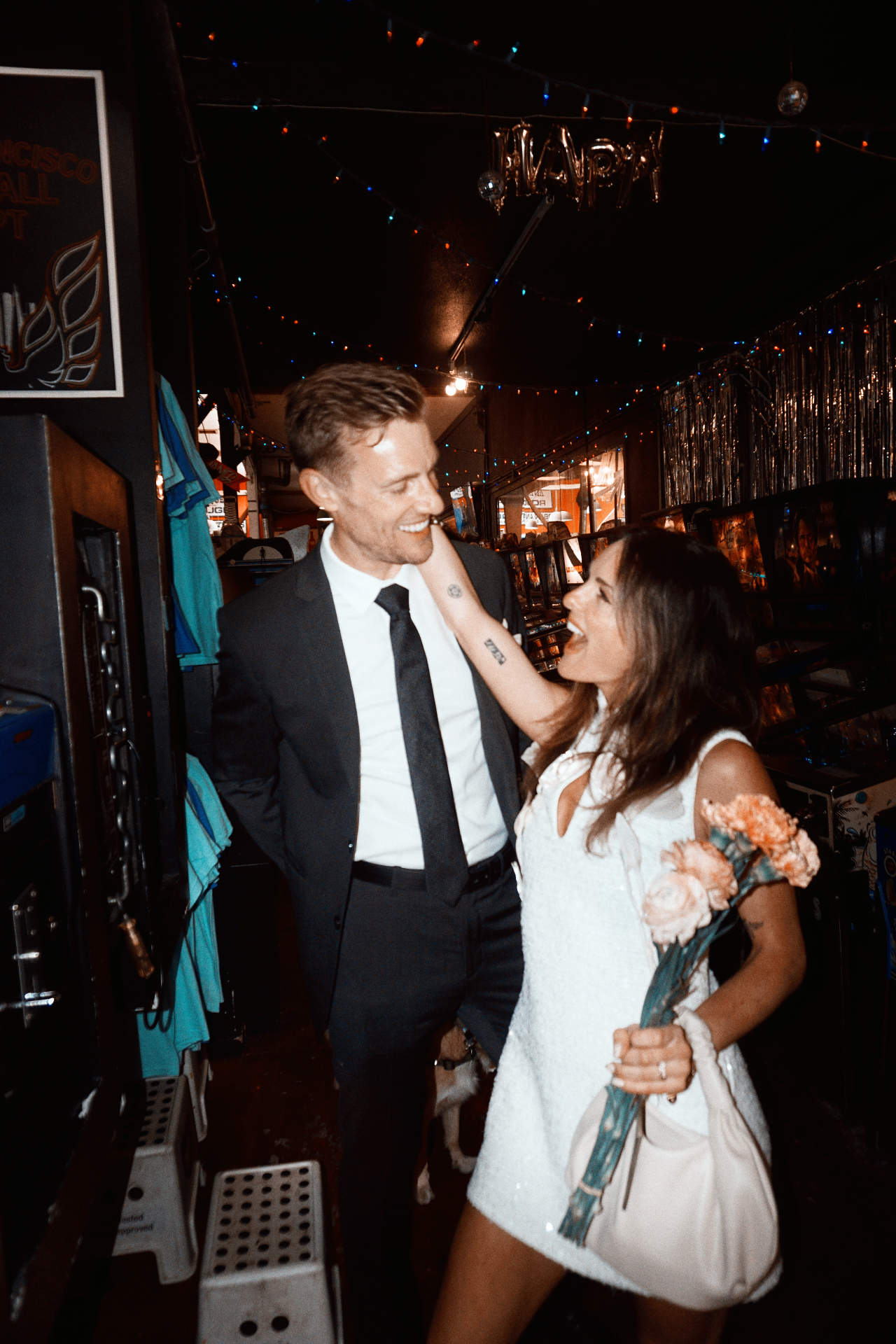 Maggie and Jono laughing together in an arcade after their City Hall photoshoot