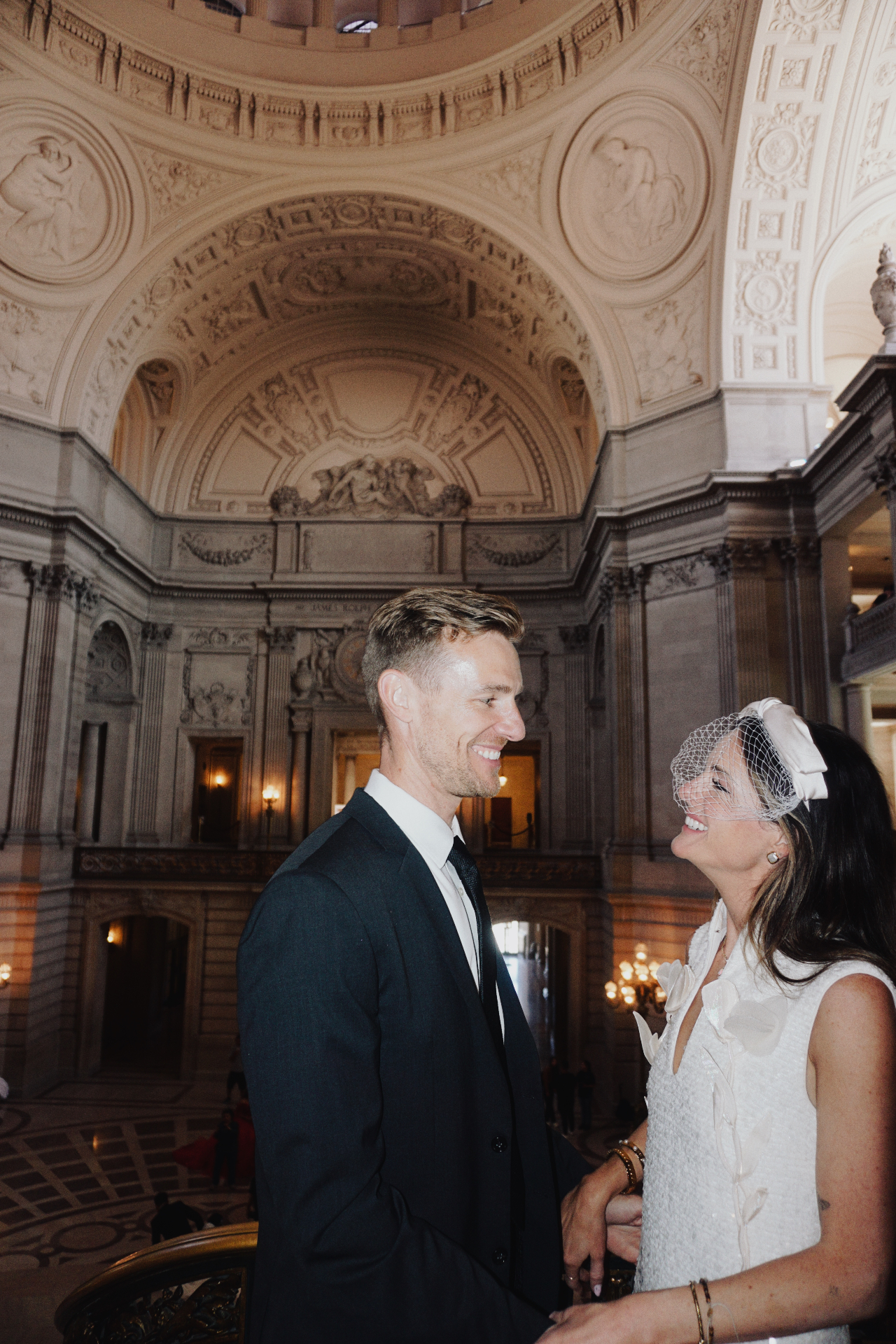 Maggie and Jono sharing a laugh beneath the ornate rotunda at San Francisco City Hall