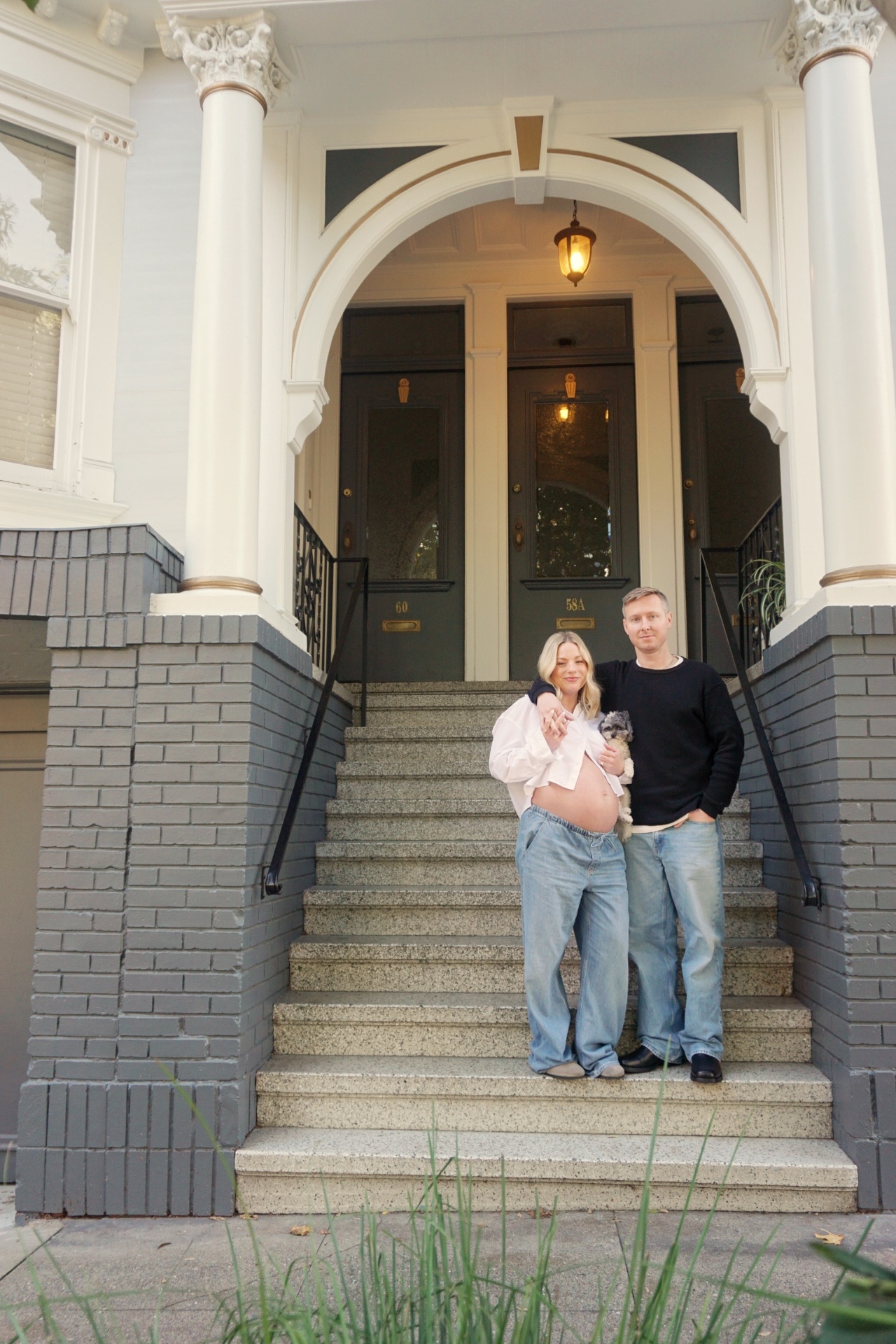 The Parson family standing on the front steps of their San Francisco Victorian home holding their small dog