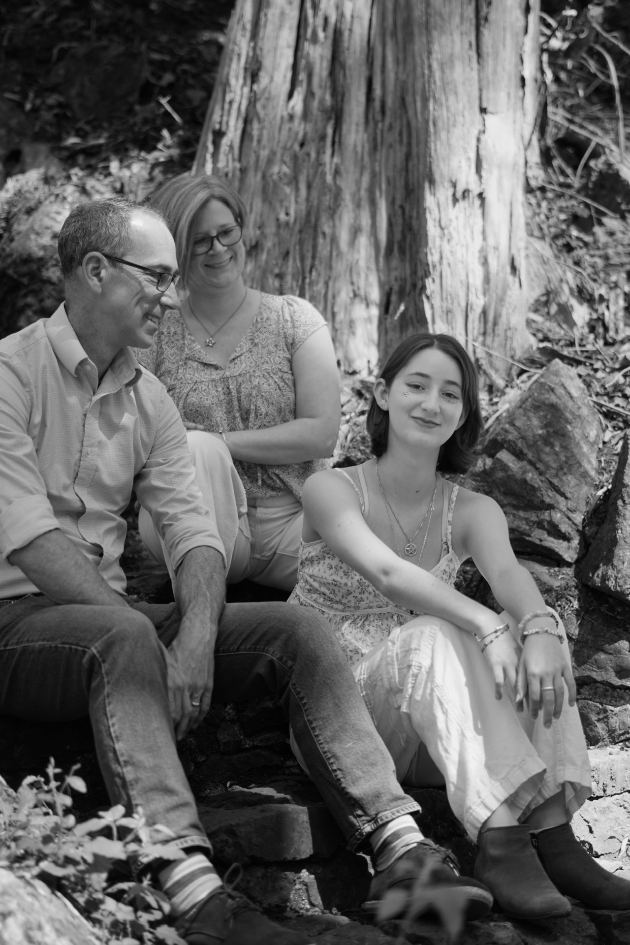 The Trimble family sitting together beneath trees during a San Francisco senior family photoshoot